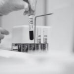 Article cover image showing blood samples and a hand